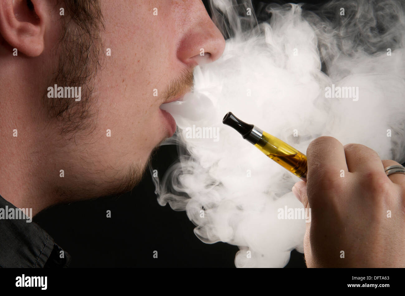 Vaping - Uomo di fumare una sigaretta elettronica ed espirando il fumo Foto Stock
