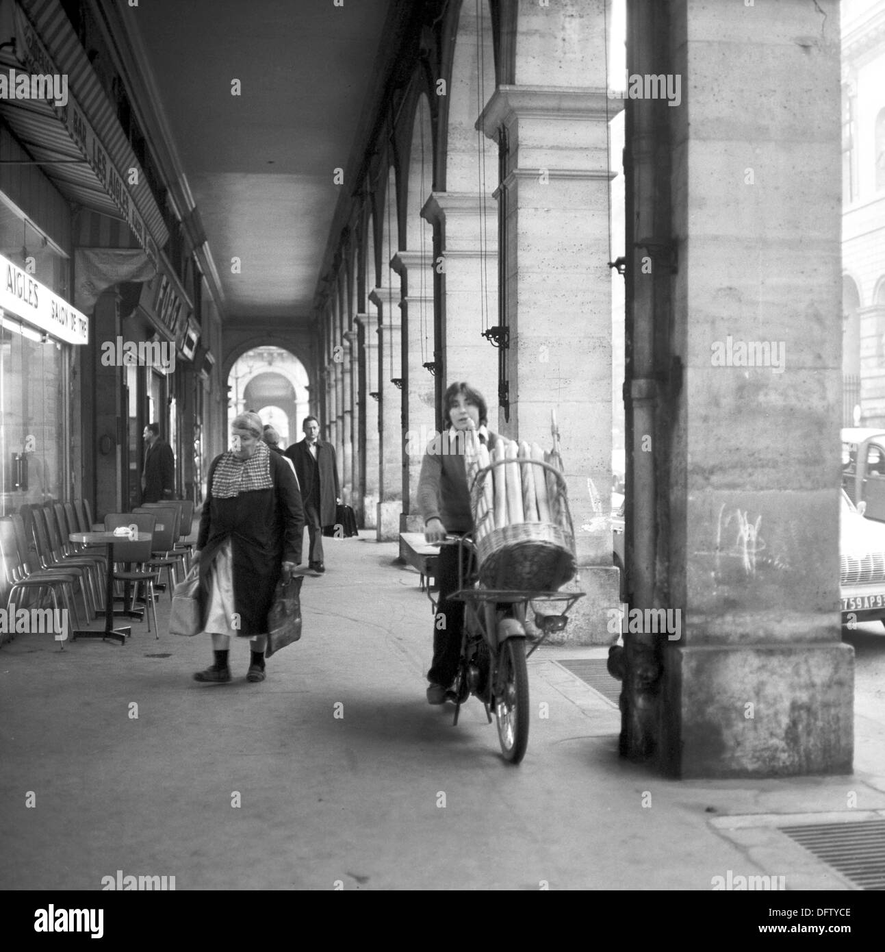 Un giovane trasporta un cestello con baguette sul suo ciclomotore in una strada dello shopping a Parigi nel novembre 1970. Foto: Wilfried Glienke Foto Stock