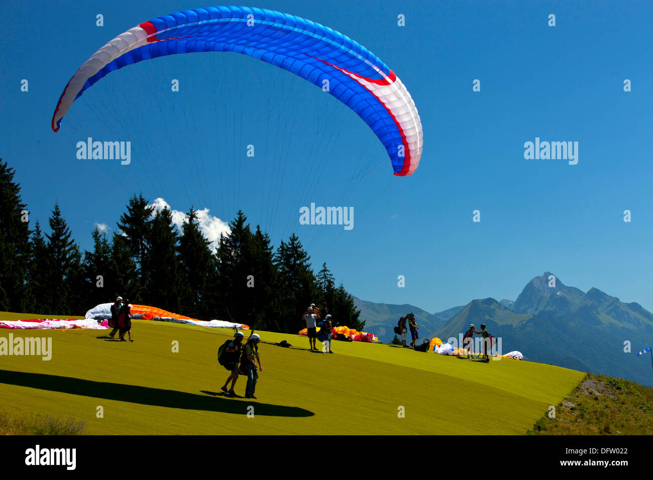 Hanglider i piloti e i passeggeri preparando per decollare in un estate alpino in Haute Savoie regione della Francia Foto Stock