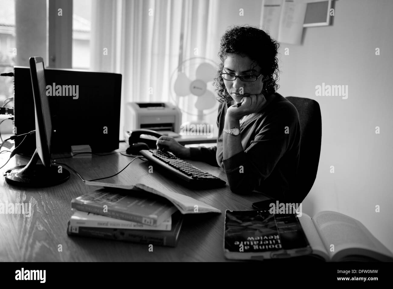 Nicole, postgraduate studente lavora su un incarico nel suo ufficio. Foto Stock