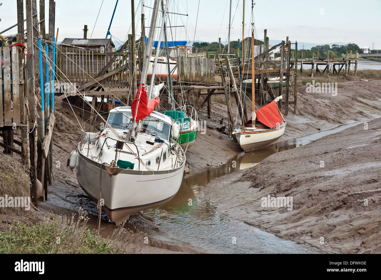 Barche in attesa che la marea nel loro fango cuccette in Skippool Creek, Fiume Wyre, Lancashire Foto Stock