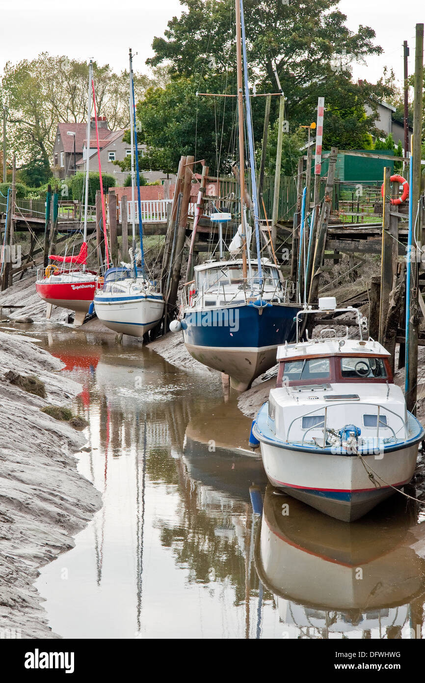 Barche in attesa che la marea nel loro fango cuccette in Skippool Creek, Fiume Wyre, Lancashire Foto Stock