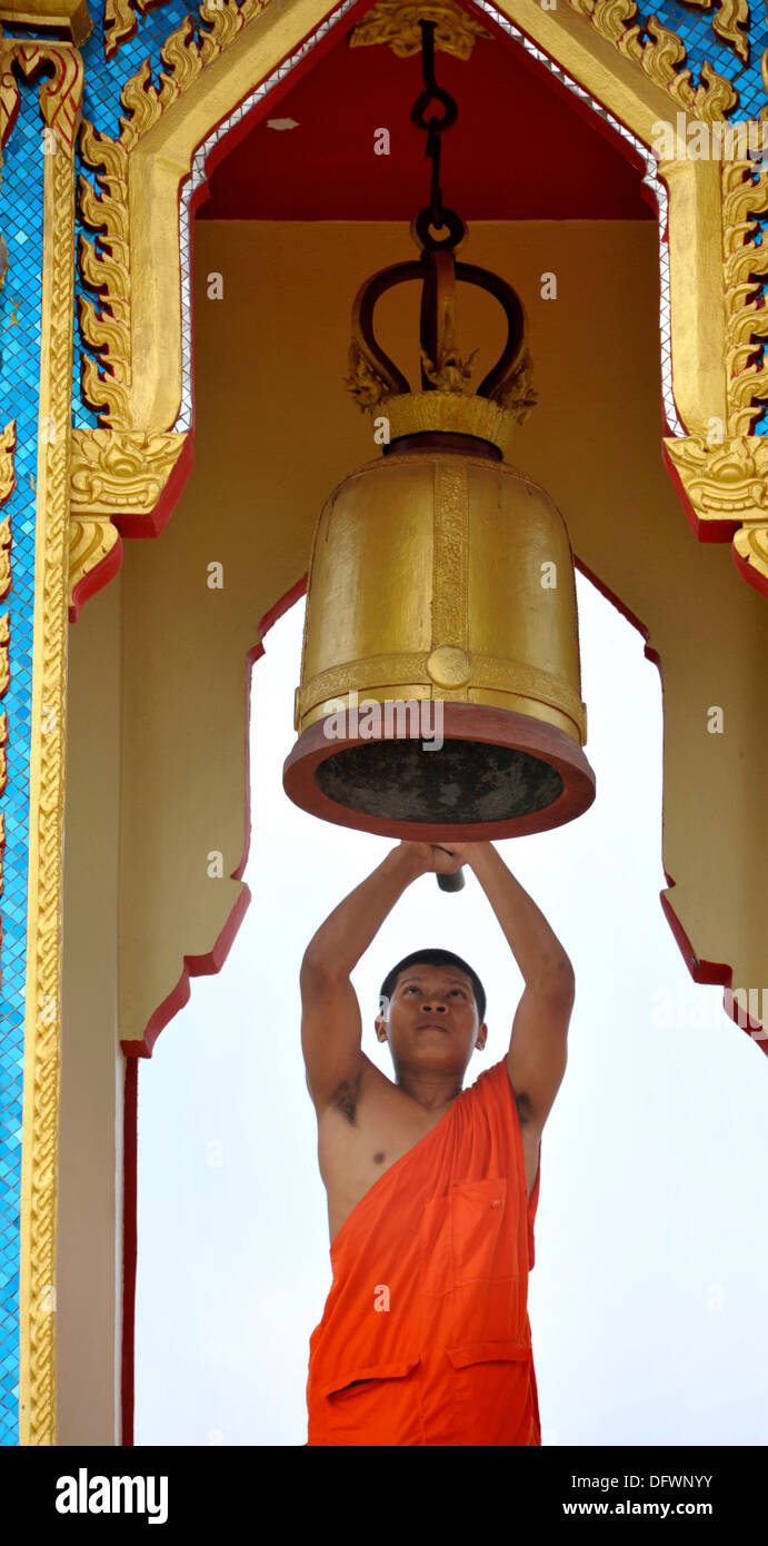 Thai monaco buddista che colpisce una campana al tempio Wat Thong Kung, accanto al fiume Mae Khlong, Amphawa, Samut Songkhran, Foto Stock