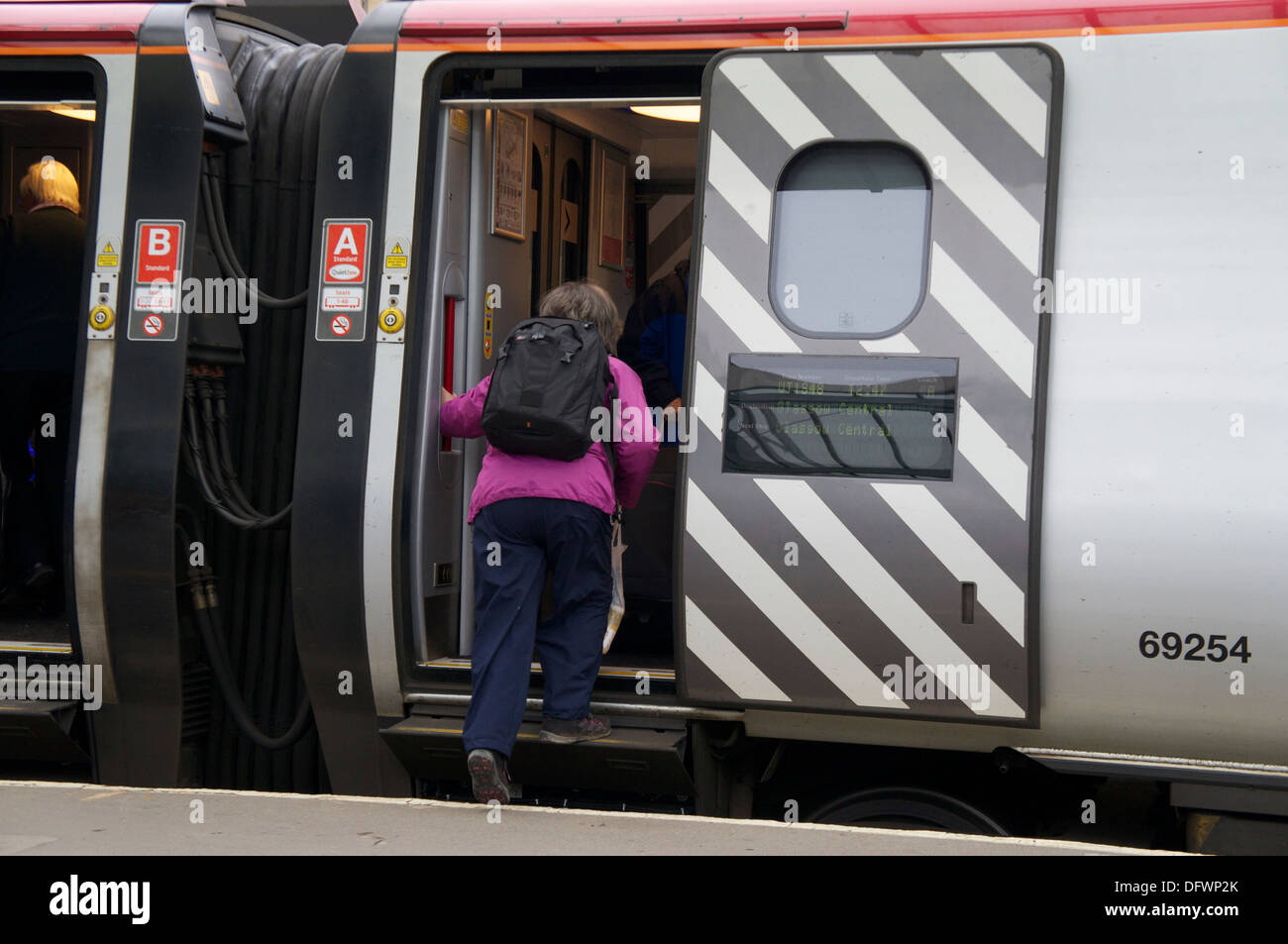 Passeggero donna a salire su una vergine Pendolino a Carlisle Stazione ferroviaria Carlisle Cumbria Inghilterra Regno Unito Regno Unito Foto Stock
