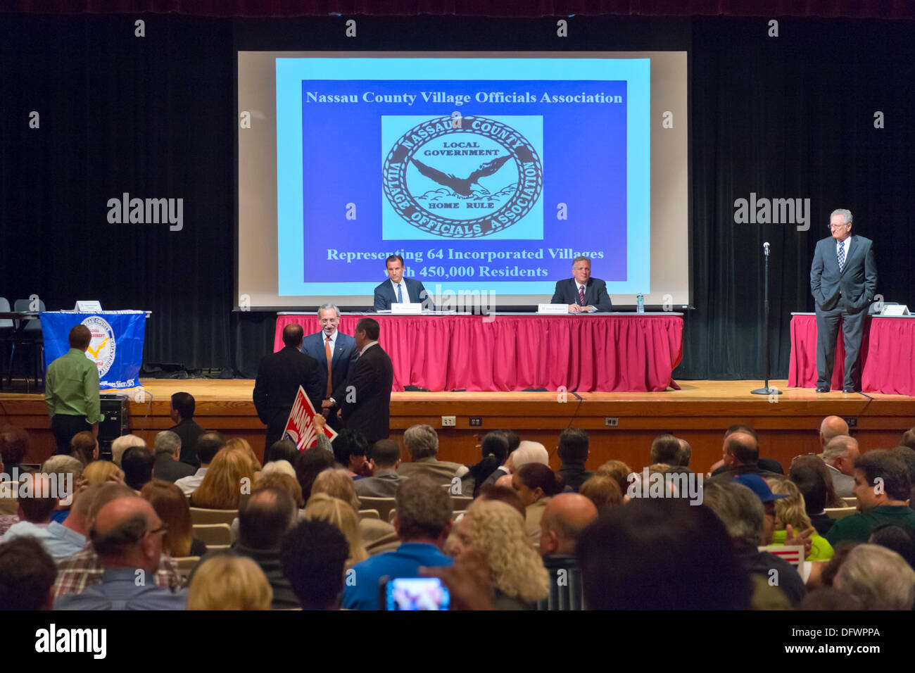 Old Westbury, New York, Stati Uniti 8 ottobre 2013. Il repubblicano EDWARD MANGANO, il Nassau County Executive, e democratici THOMAS SUOZZI, ex County Executive, R-L a tabella rossa, si fronteggiano in un dibattito ospitato dalla contea di Nassau Village funzionari di associazione, che rappresenta 64 incorporati nei villaggi con 450.000 residenti, come gli avversari di fronte a una rivincita nel 2013 elezioni di novembre. Credito: Ann e Parry/Alamy Live News Foto Stock