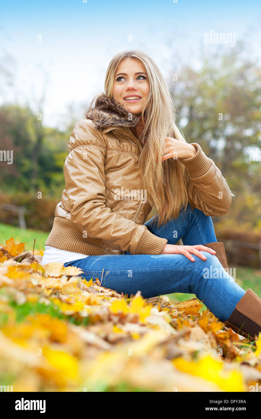 Giovane donna in un parco in autunno Foto Stock