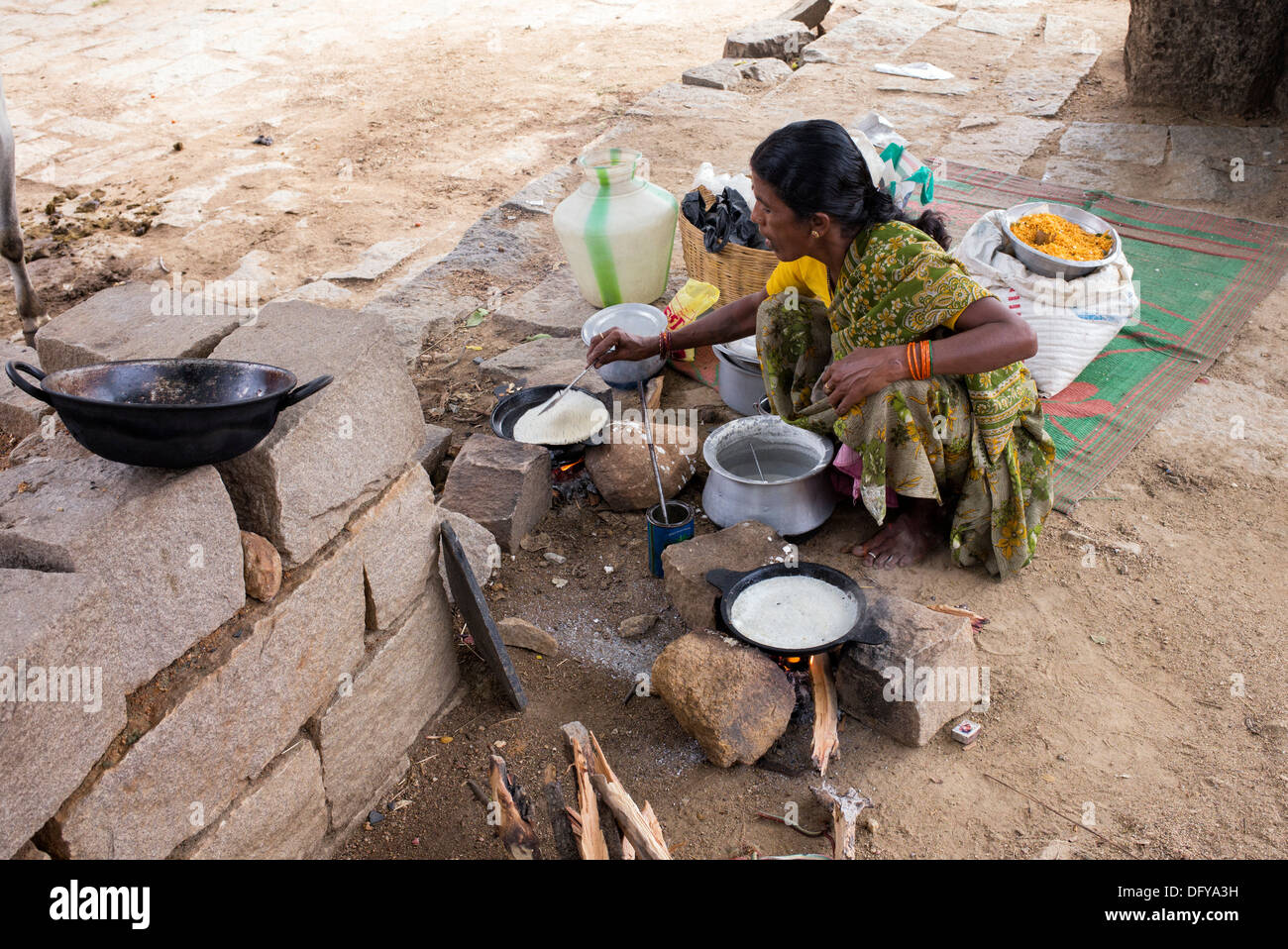 Donna indiana che dosa di cottura per la gente per strada in una zona rurale villaggio indiano. Andhra Pradesh, India Foto Stock