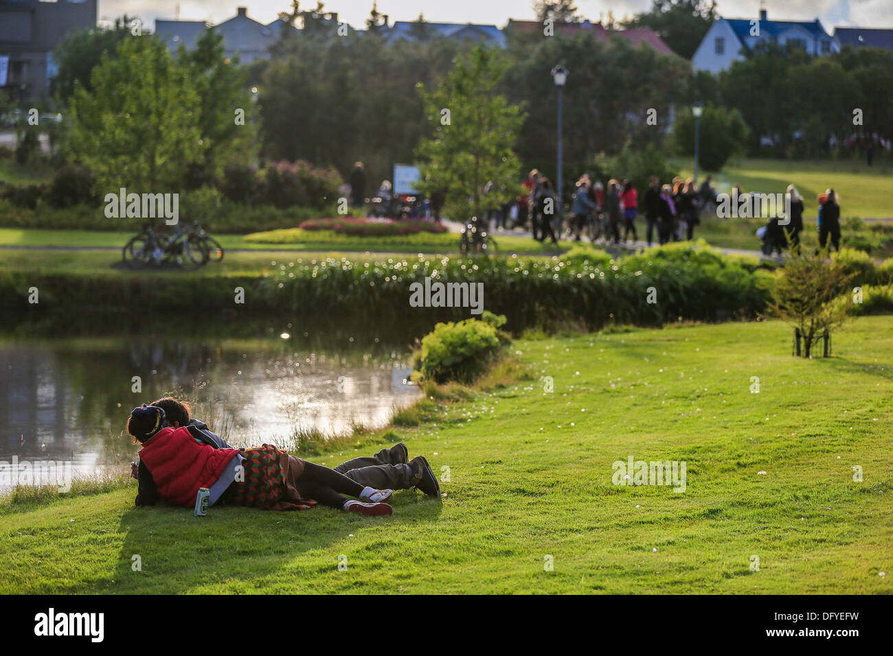 Giovane e gode di una bella giornata d'estate nel parco, Reykjavik, Islanda Foto Stock