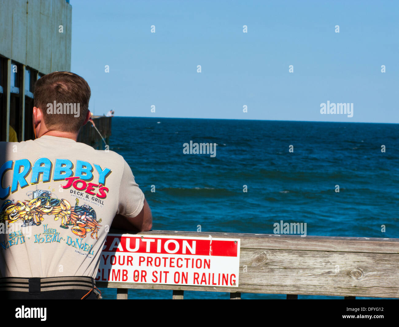 Uomo che indossa scontrosa Joe's T shirt sul molo in Daytona Beach Shores Foto Stock