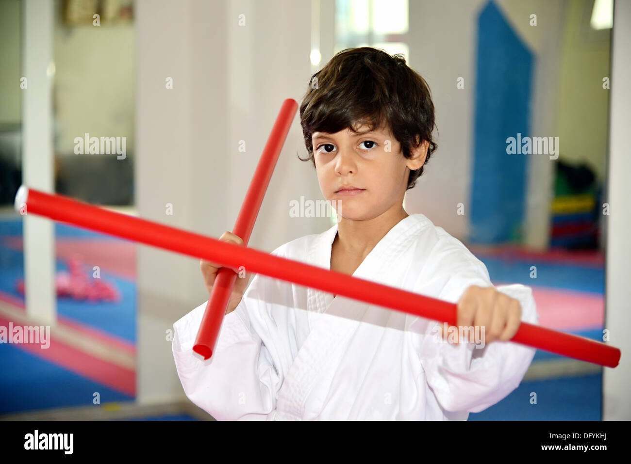 Arti marziali boy tenendo due bastoni rosso denominato ka-li - bastoncini di combattimento Foto Stock