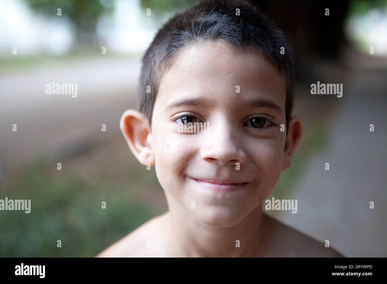 Close up di ispanico boy in piedi nel suo quartiere al crepuscolo. Foto Stock