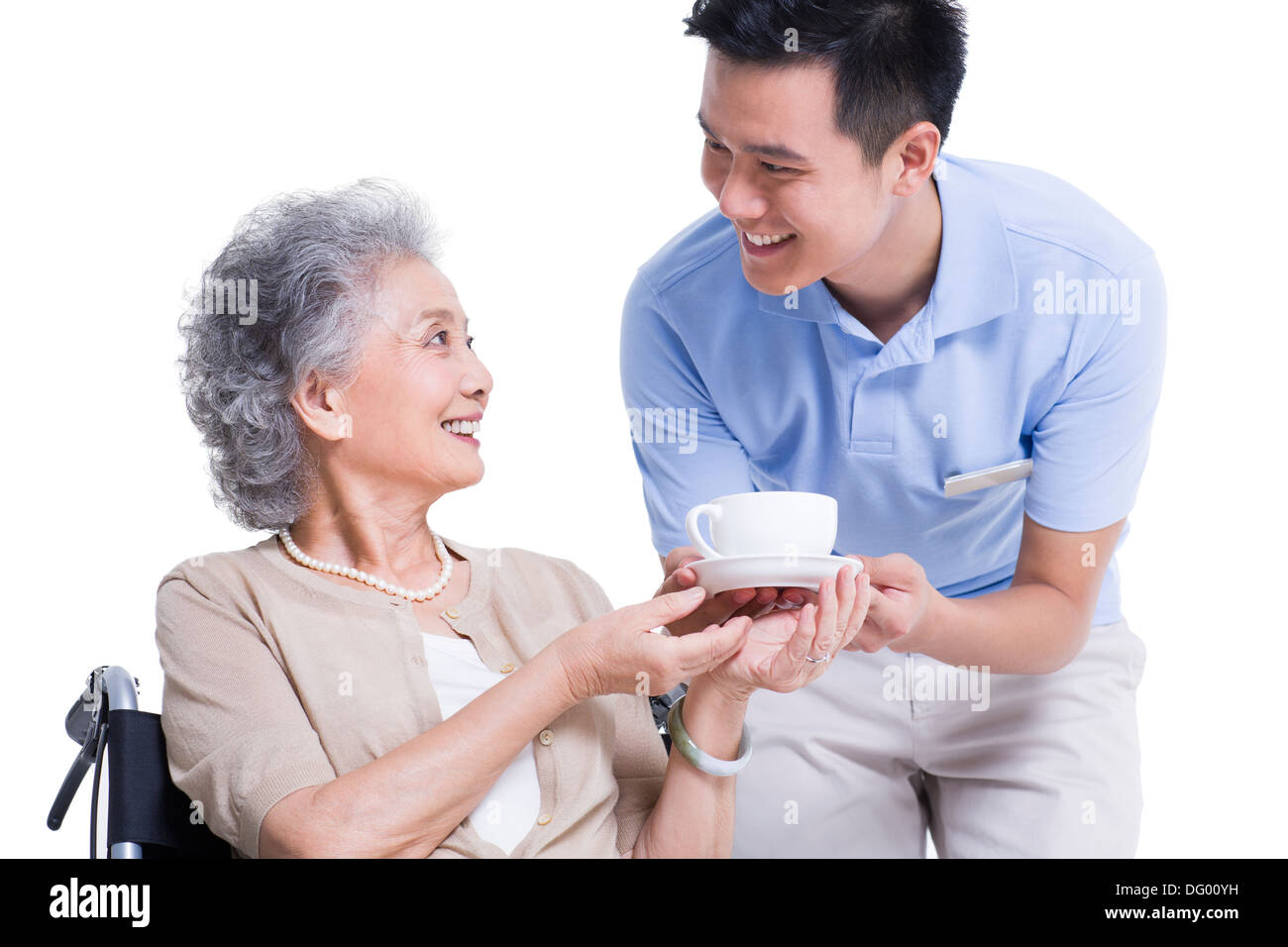 Maschio lavoratore infermieristico che serve tè al senior donna Foto Stock