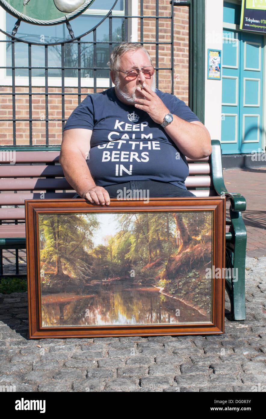 Uomo obesi fumatori e tenendo la pittura Gosport, Hampshire, Inghilterra, Regno Unito Foto Stock