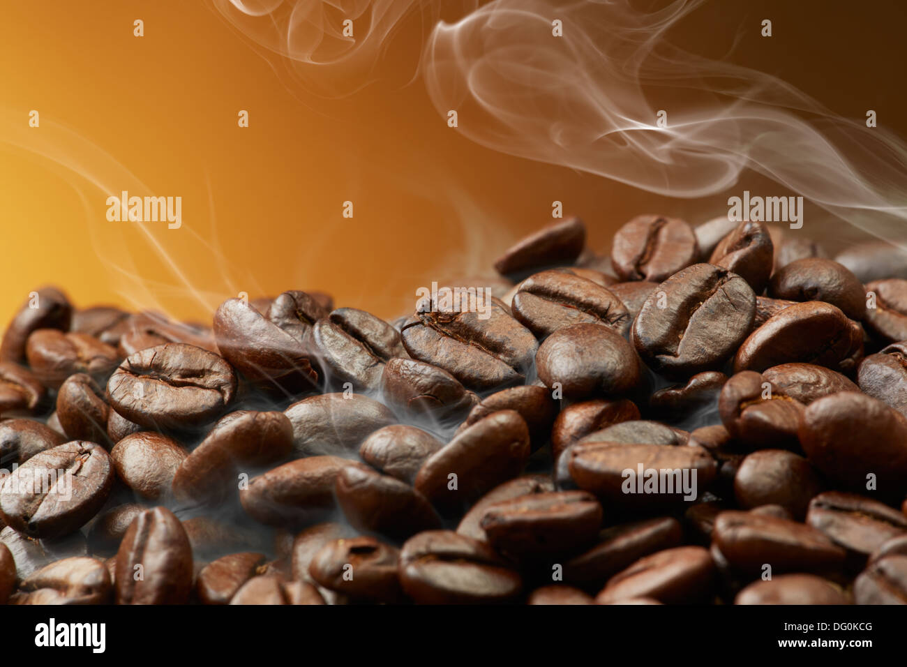 Pila di chicchi di caffè tostati con fumo Foto Stock
