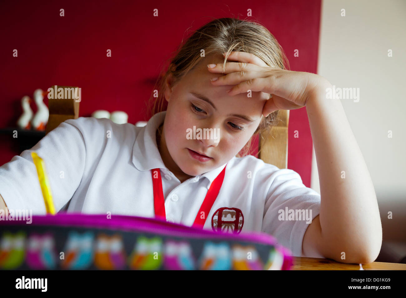 Dodici anni ragazza caucasica in uniforme scolastica facendo i compiti di scuola Foto Stock