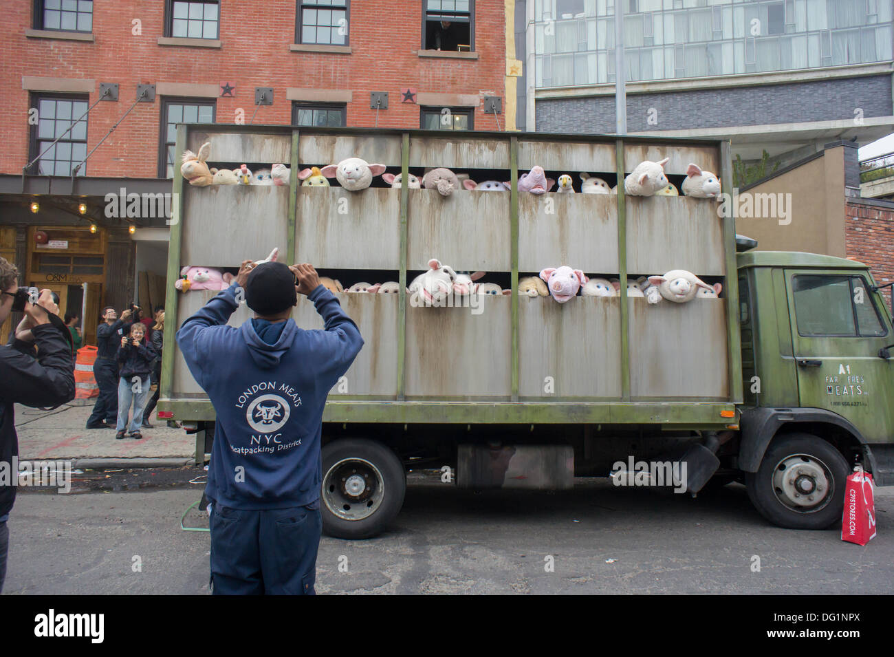 New York City, NY, STATI UNITI D'AMERICA . Undicesimo oct, 2013. Gli appassionati di Banksy gregge del quartiere alla moda di Meatpacking District di New York su Venerdì, Ottobre 11, 2013 per vedere l'undicesima puntata di Banksy arte, "Le Sirene degli agnelli". Questo particolare pezzo scultoreo consiste in un macello carrello riempito con belati animali di peluche, controllata da burattinai, che furono condotti in giro da un conducente che è rimasto nel carattere. Credito: Richard Levine/Alamy Live News Foto Stock