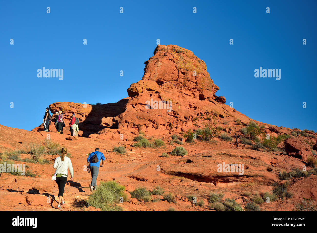 Gli escursionisti a piedi fino a pietra arenaria rossa collina. Southern Utah, Stati Uniti d'America. Foto Stock