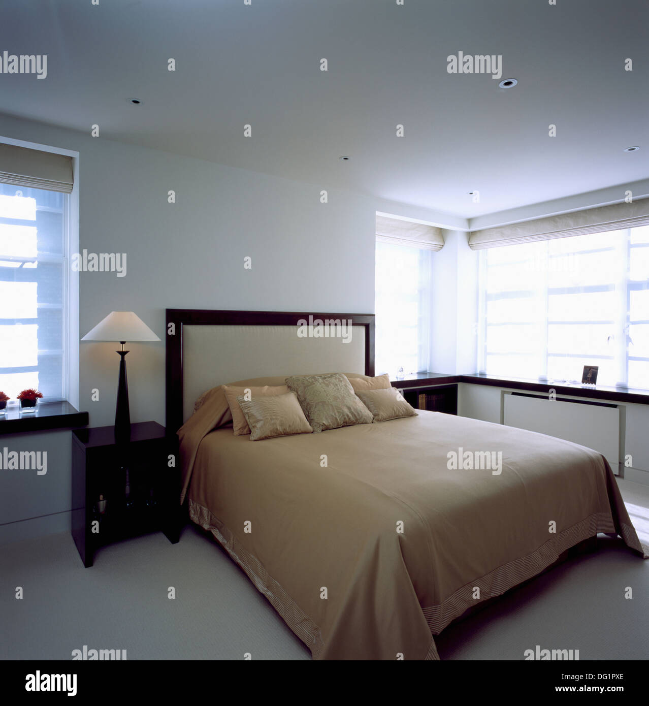 Letto Beige coperchio sul letto imbottito in genere maschile moderno appartamento camera con lampada bianco su nero comodino Foto Stock
