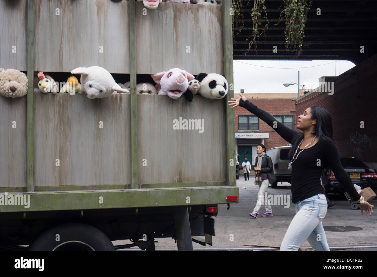 New York City, NY, STATI UNITI D'AMERICA. Undicesimo oct, 2013. Gli appassionati di Banksy gregge del quartiere alla moda di Meatpacking District di New York su Venerdì, Ottobre 11, 2013 per vedere l'undicesima puntata di Banksy arte, "Le Sirene degli agnelli". Questo particolare pezzo scultoreo consiste in un macello carrello riempito con belati animali di peluche, controllata da burattinai, che furono condotti in giro da un conducente che è rimasto nel carattere. Credito: Francesca Roberts/Alamy Live News Foto Stock