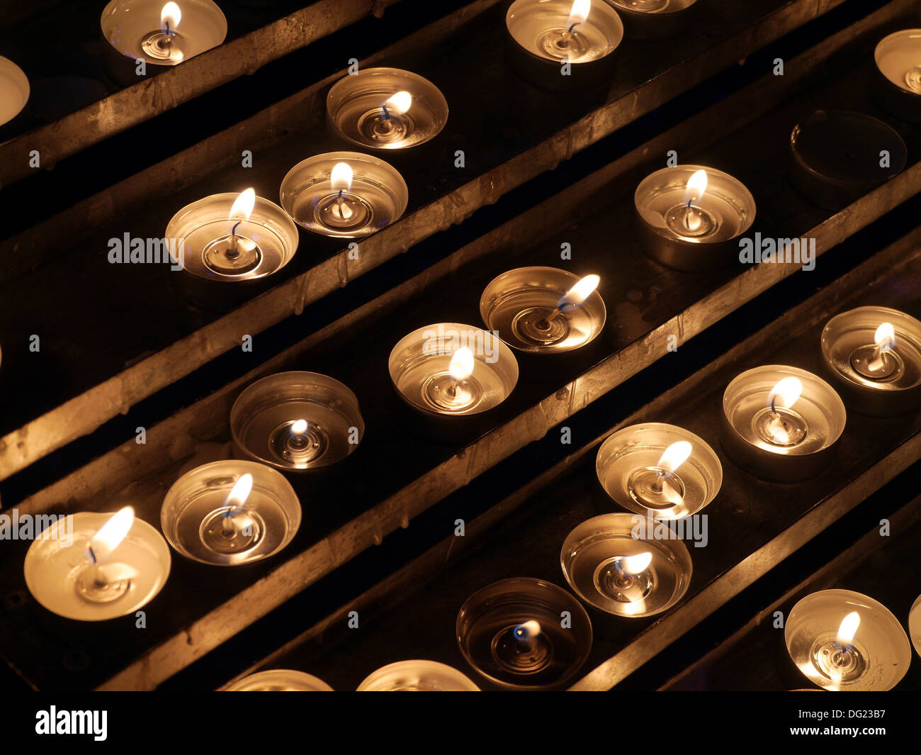 Righe di acceso candele votive Foto Stock