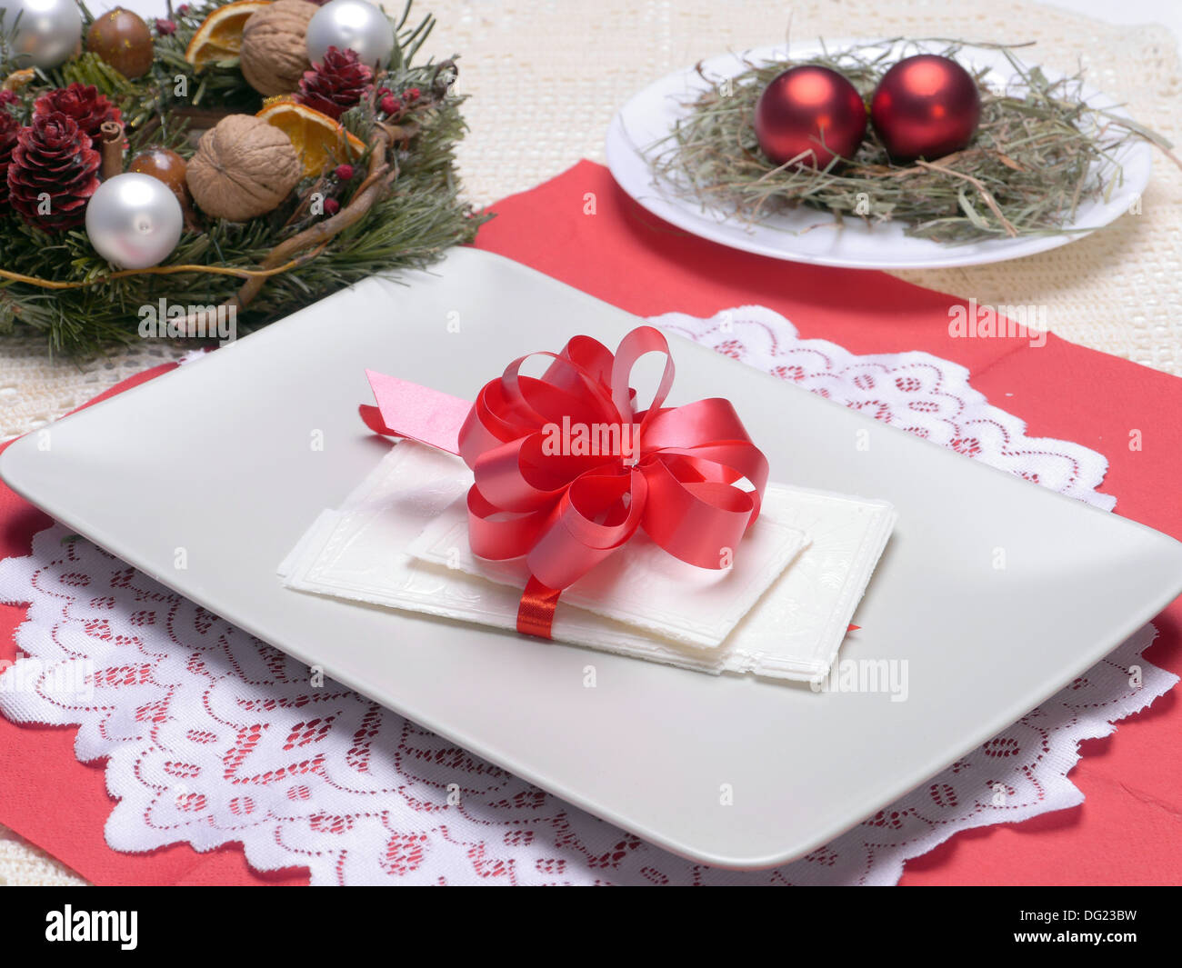 Tradizionale per la Vigilia di Natale fetta di bianco su una piastra con coccarda rossa Foto Stock