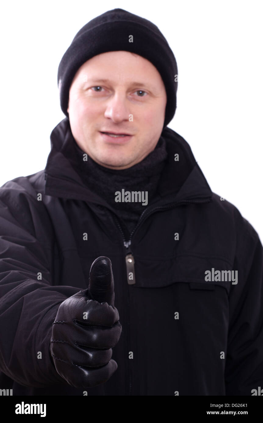 Un uomo in inverno-vestiti sta tenendo il suo pollice in alto Foto Stock