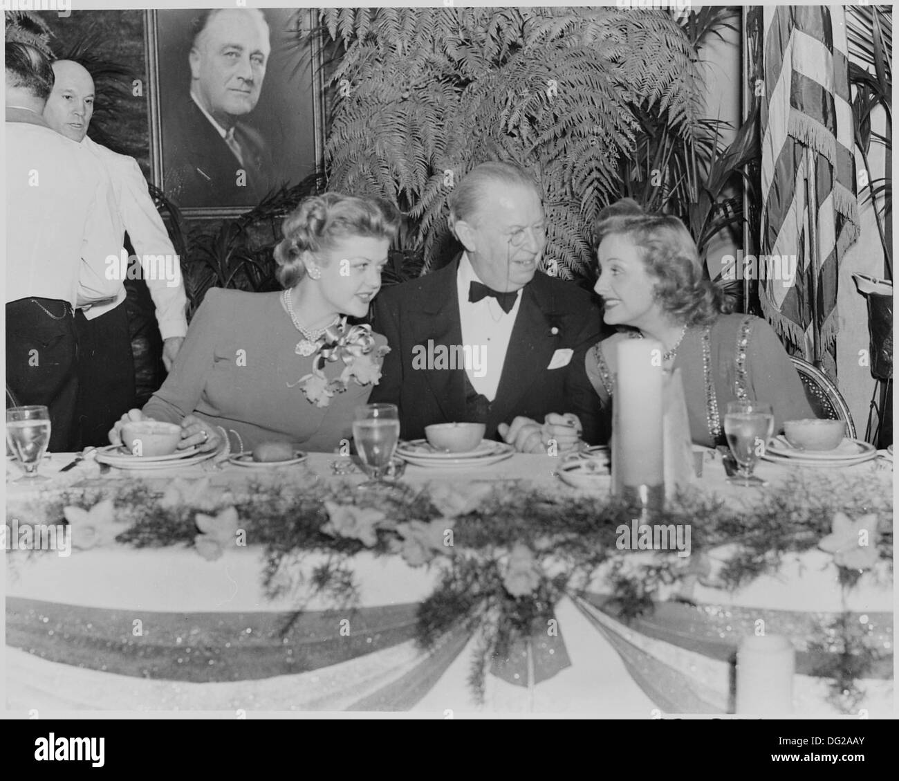 Questa fotografia mostra le star del cinema Angela Lansbury, Charles Coburn e Constance Moore a un tavolo durante un evento ospitato dal presidente Franklin D. Roosevelt, che mostra il legame di Hollywood con le figure politiche durante gli anni '1940 Foto Stock