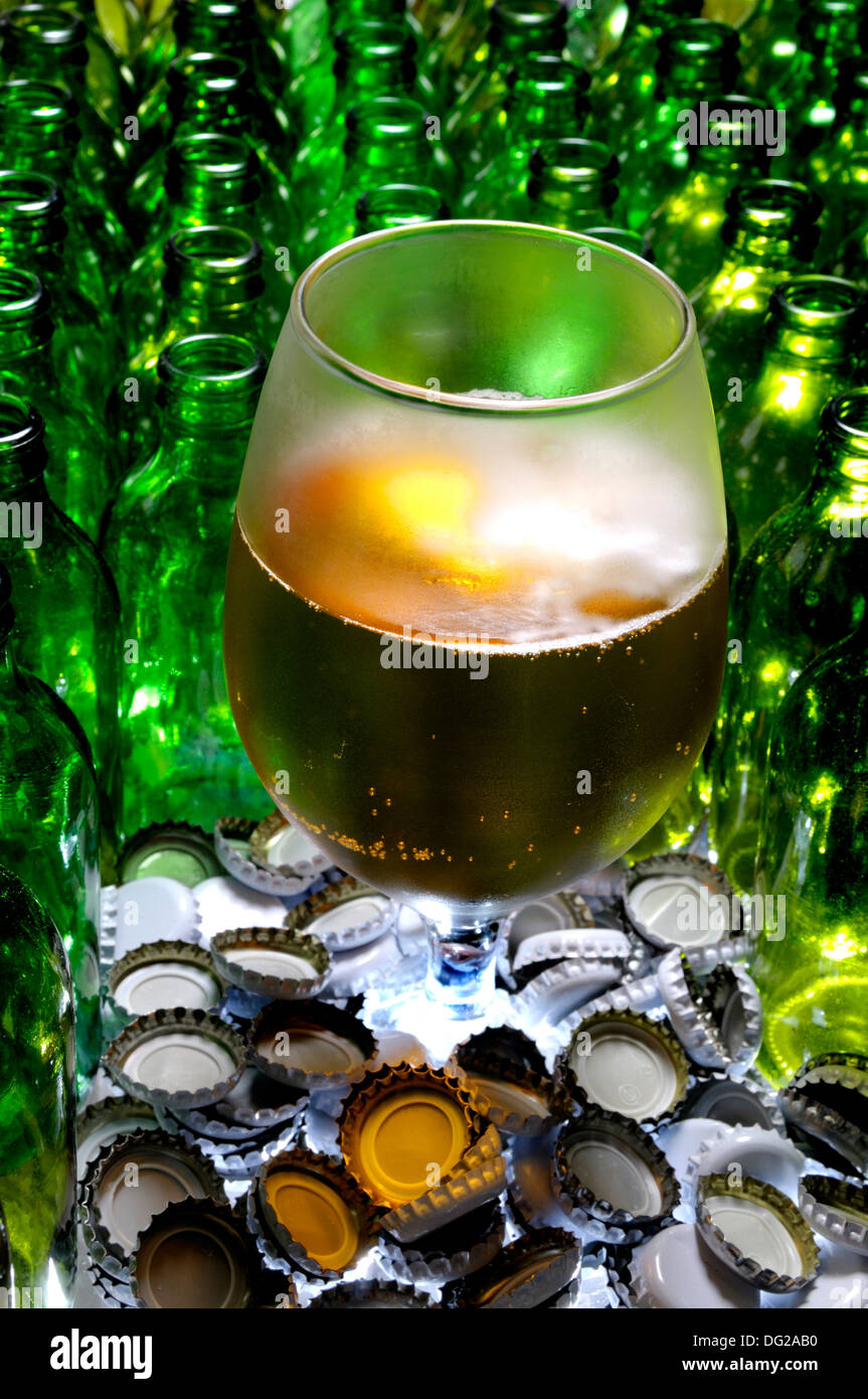 Bicchiere di birra con bottiglie vuote e tappi Foto Stock