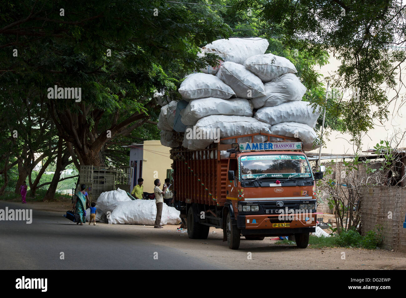 Indian uomini il sovraccarico di un carrello con rifiuti domestici per il riciclaggio. Andhra Pradesh, India Foto Stock