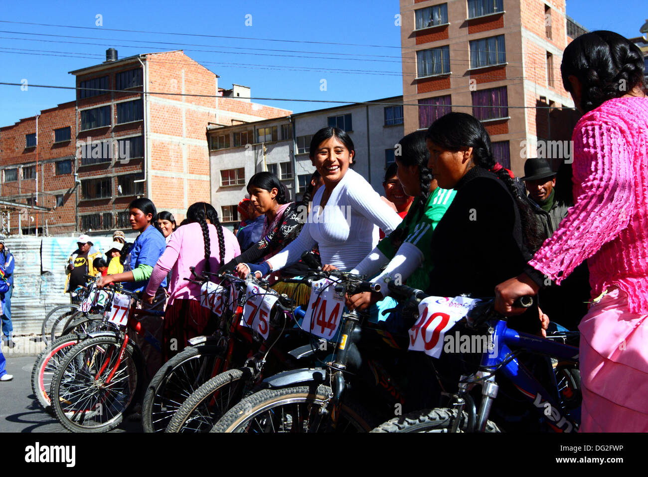 El alto, Bolivia. 12 ottobre 2013. Le concorrenti si schierano prima dell'inizio di una corsa ciclistica Cholitas per donne indigene Aymara. La gara si svolge ad un'altitudine di poco più di 4.000 m lungo le strade principali della città di El alto (sopra la Paz) per il Womens Day boliviano, che si è svolto ieri venerdì 11 ottobre. Crediti: James Brunker / Alamy Live News Foto Stock