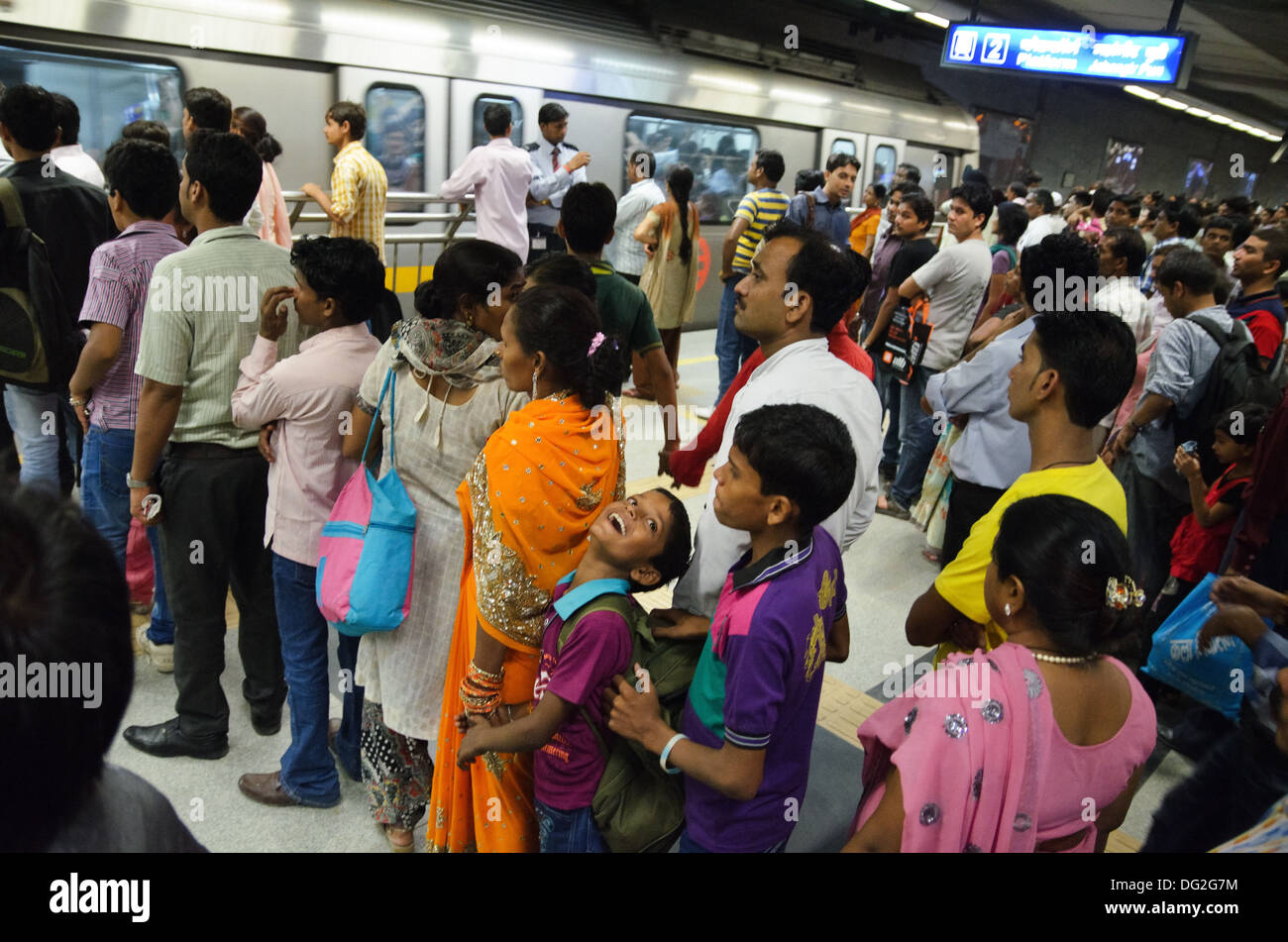 Code di passeggeri in attesa di un treno della metropolitana di Delhi del sistema ferroviario, India Foto Stock