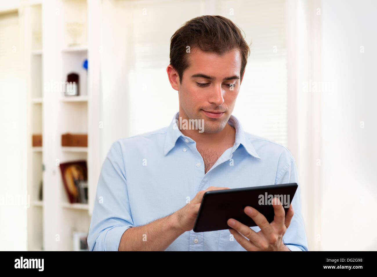 Lavoro maschio sulla tavoletta digitale in casa Foto Stock
