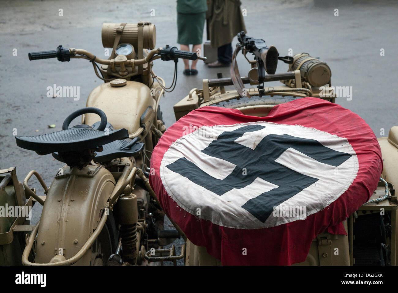 Motocicletta tedesca e Side-car, e bandiera nazista swastika all'evento 'Ferrovia in guerra' North Yorks Moors Railway (NYMR) 2013. La stazione di Levisham, è stata decorata con manifesti d'epoca, e segni francesi durante il "Weekend della guerra" (NYMR) per diventare "le Visham" nel nord della Francia. Il raduno, una ricreazione di un villaggio francese occupato dalla seconda guerra mondiale, seconda guerra mondiale, seconda guerra mondiale, seconda guerra mondiale, WW2 truppe tedesche. La svastika è un antico simbolo che era in uso in molte culture diverse per almeno 5.000 anni prima che Adolf Hitler adottasse la bandiera Foto Stock