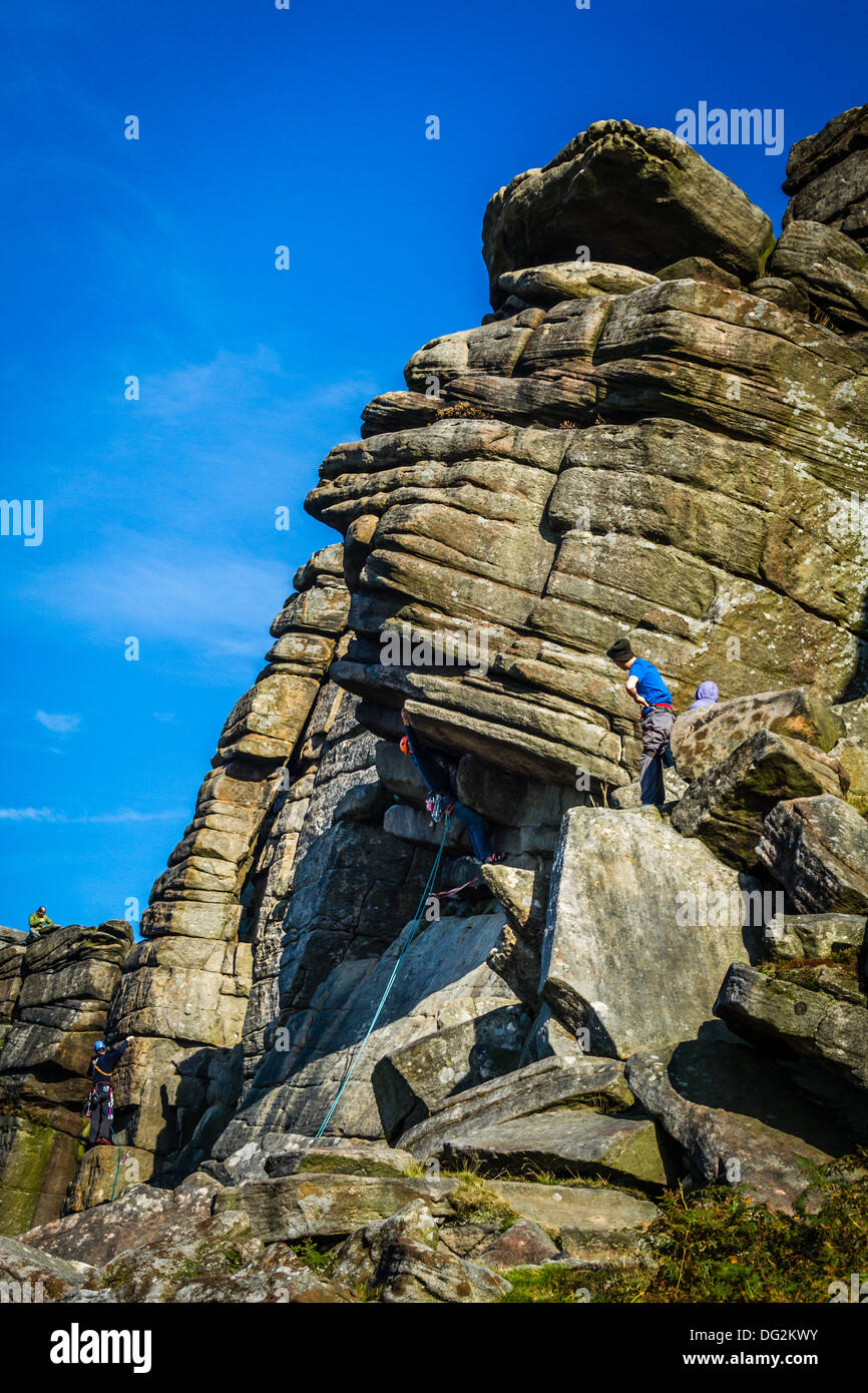 Maschio di scalatore di persona che si avvicina al nocciolo della Flying contrafforte diretto, Stanage, Peak District, REGNO UNITO Foto Stock