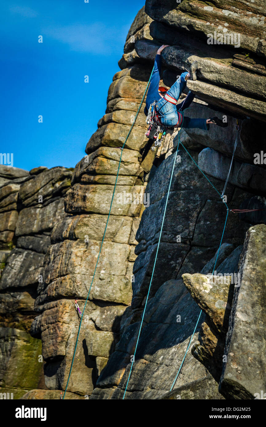 Persona che fa un tacco gancio sul nocciolo di arrampicata: Flying contrafforte diretto, Stanage, Peak District, REGNO UNITO Foto Stock