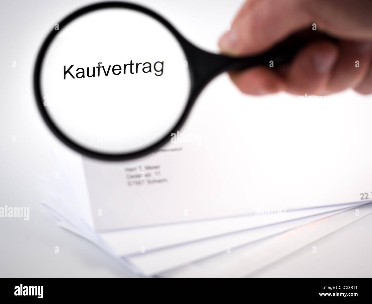 Lettera con un contratto di vendita rappresentato da un vetro di ingrandimento Foto Stock