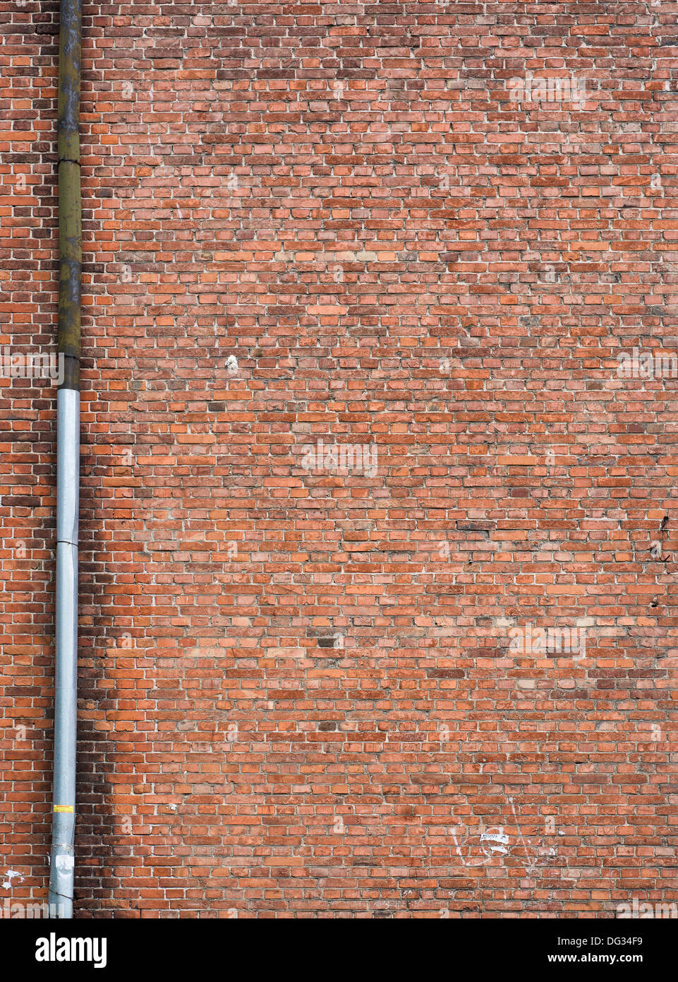 Rosso antico muro di mattoni texture con tubo Foto Stock
