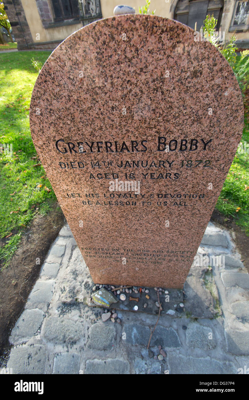 Città di Edimburgo in Scozia. Un granito rosso headstone oltre Greyfriars Bobby tomba nel cimitero di Greyfriars Kirk. Foto Stock