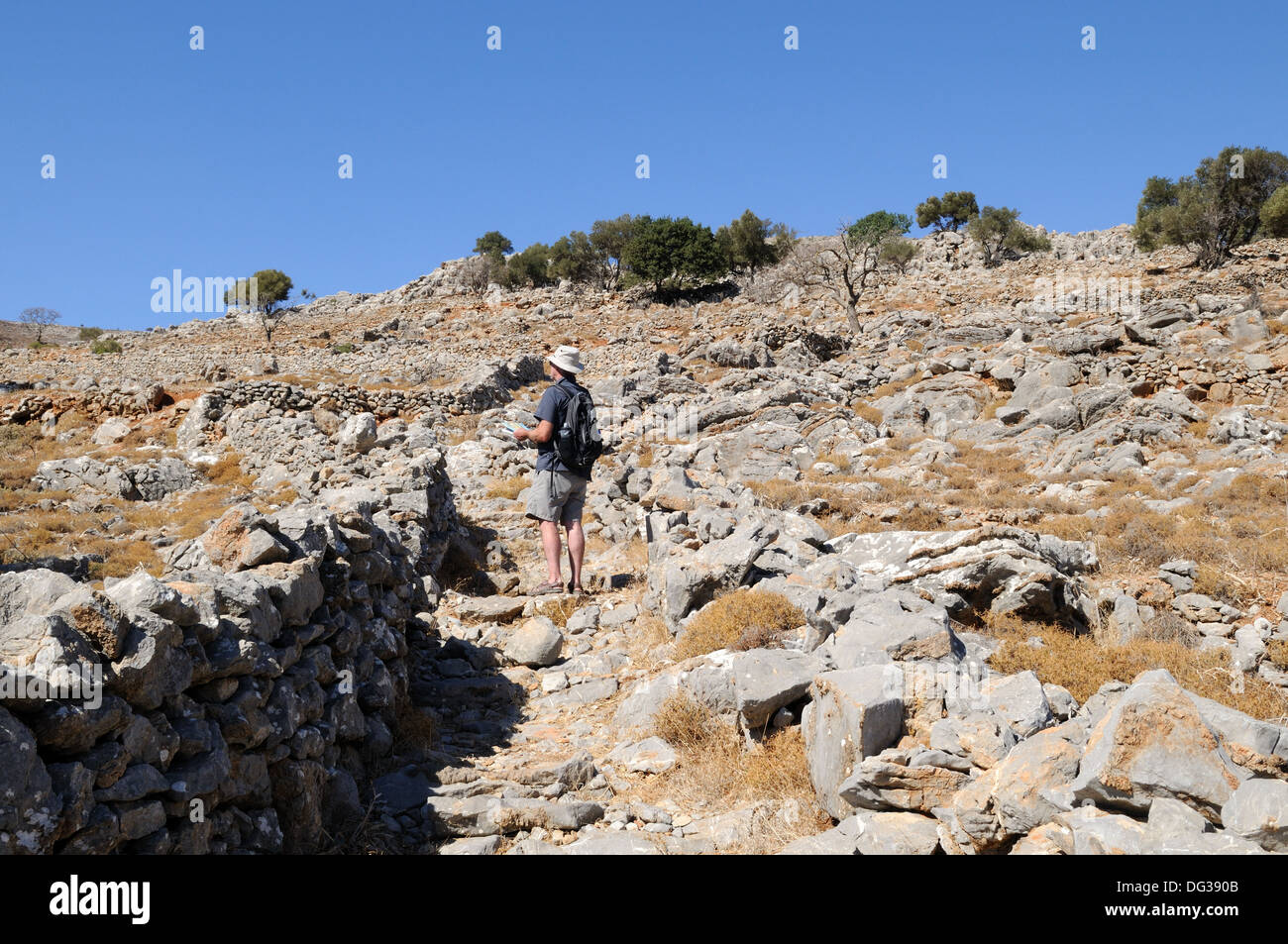Tourist walker controllo sulla mappa il percorso per Mikro Chorio abandned village Tilos Greeck Isola del Dodecanneso Grecia Foto Stock