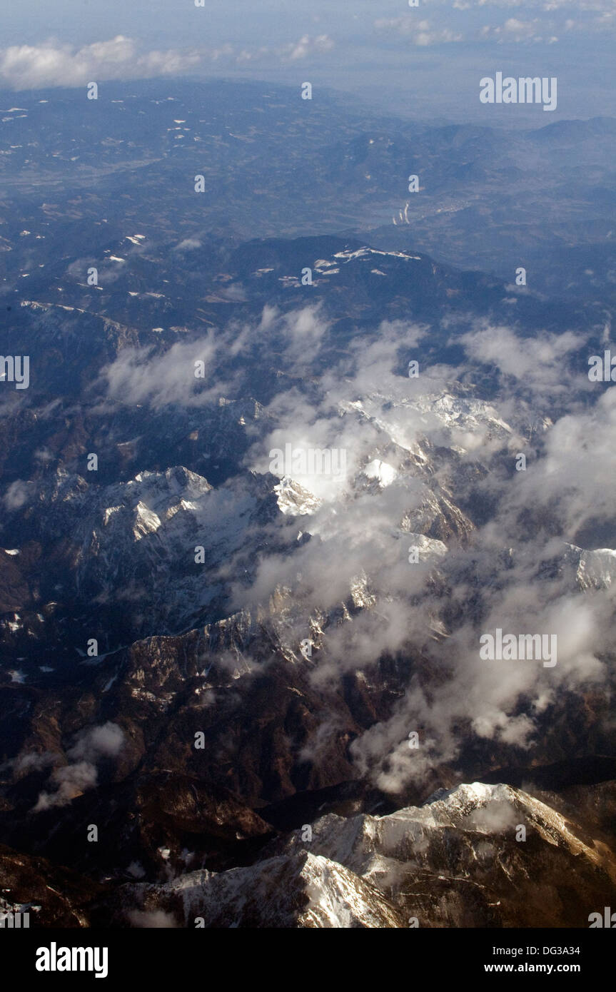 Vedute aeree di snow clad robusto e roccia di fronte montagne delle Alpi con la nuvola di luce diffusa al di sopra Foto Stock