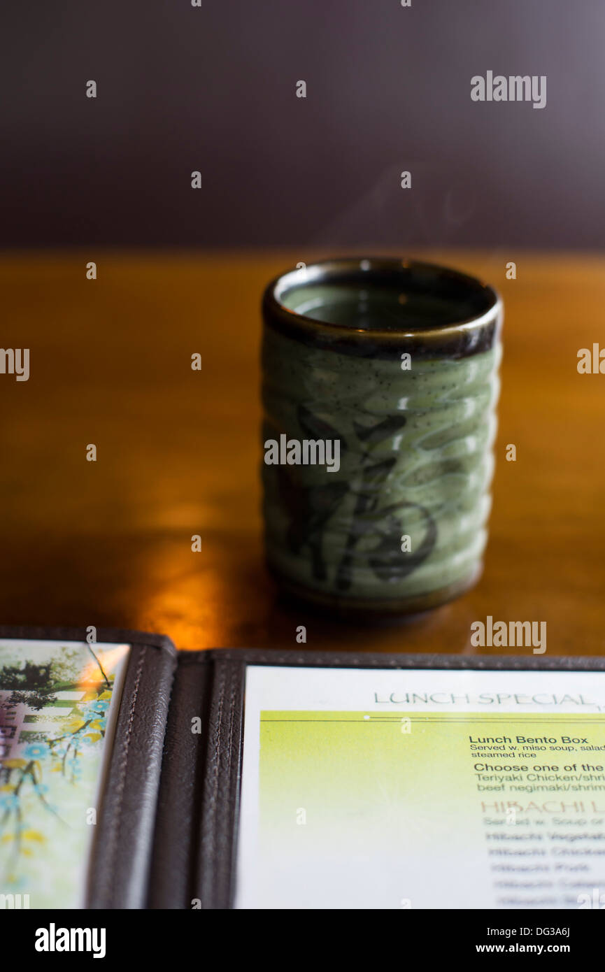 Tazza di tè verde e il menu sul tavolo Ristorante Foto Stock