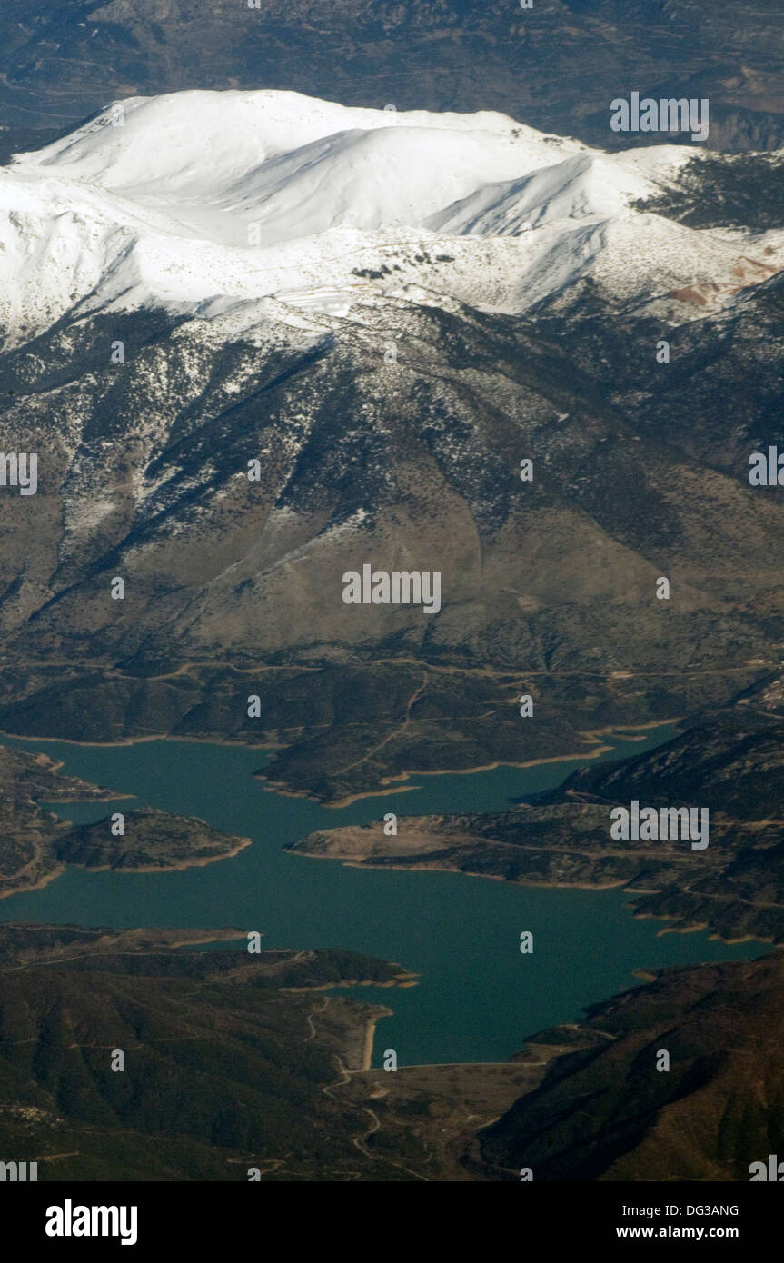 Vista aerea del bianco scintillante innevate per la gamma della montagna delle Alpi e del lago verde smeraldo in primo piano Foto Stock