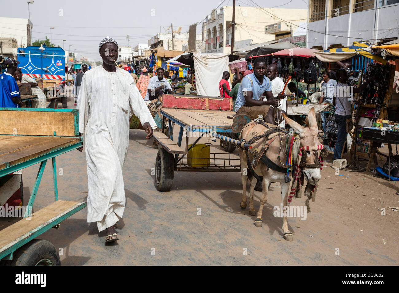 Il Senegal, Touba. Scena di strada. L'uomo ha un chewing stick nella sua bocca, per la pulizia dei denti. Foto Stock