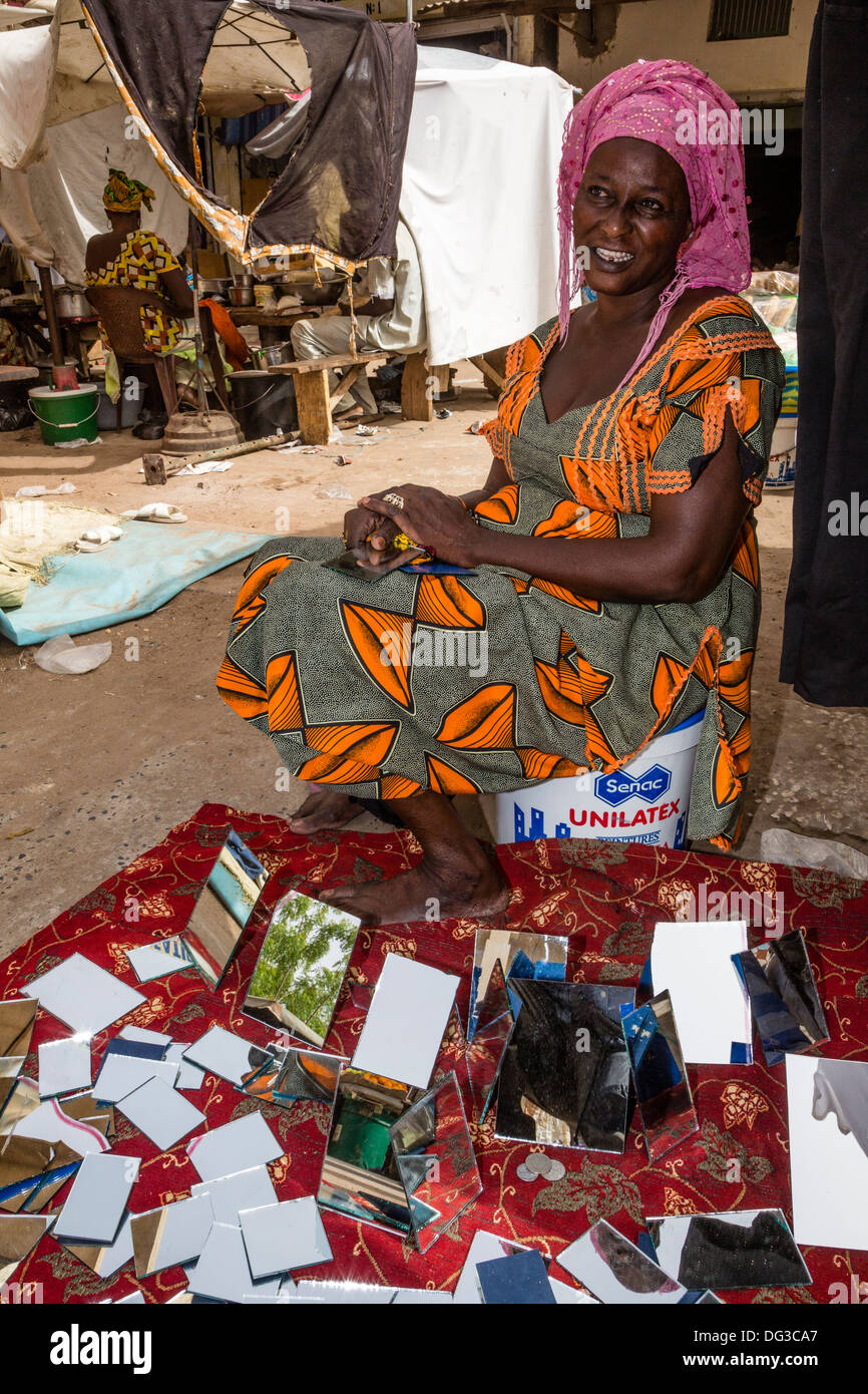 Il Senegal, Touba. La donna gli specchi di vendita nel mercato. Foto Stock