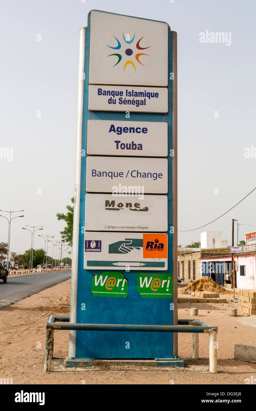 Il Senegal, Touba. Pannelli pubblicitari per la Banca islamica del Senegal e di altri servizi di trasferimento di denaro. Foto Stock