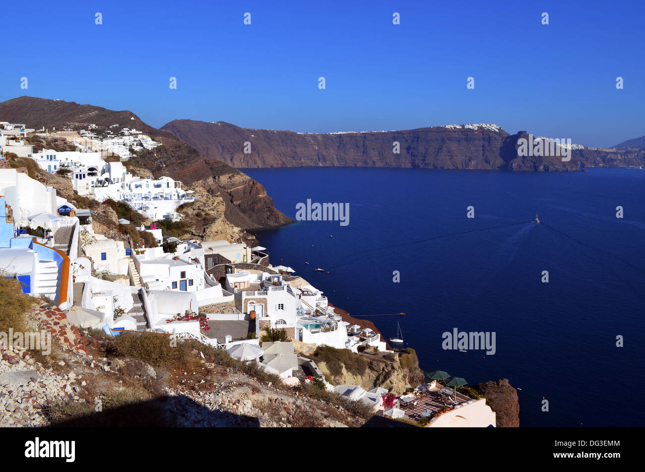 L'alta costa rocciosa dell'isola di Santorini con bianche case e alberghi per accogliere un sempre crescente industria turistica. Foto Stock