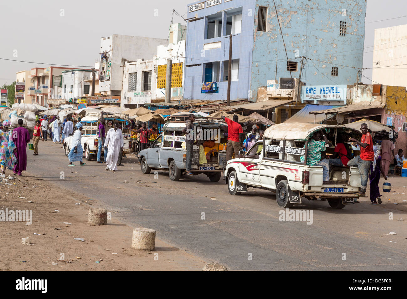 Il Senegal, Touba. Il trasporto locale. Pick-up con i giovani uomini di solito appeso sul retro della scheda In esecuzione, passeggeri all'interno. Foto Stock