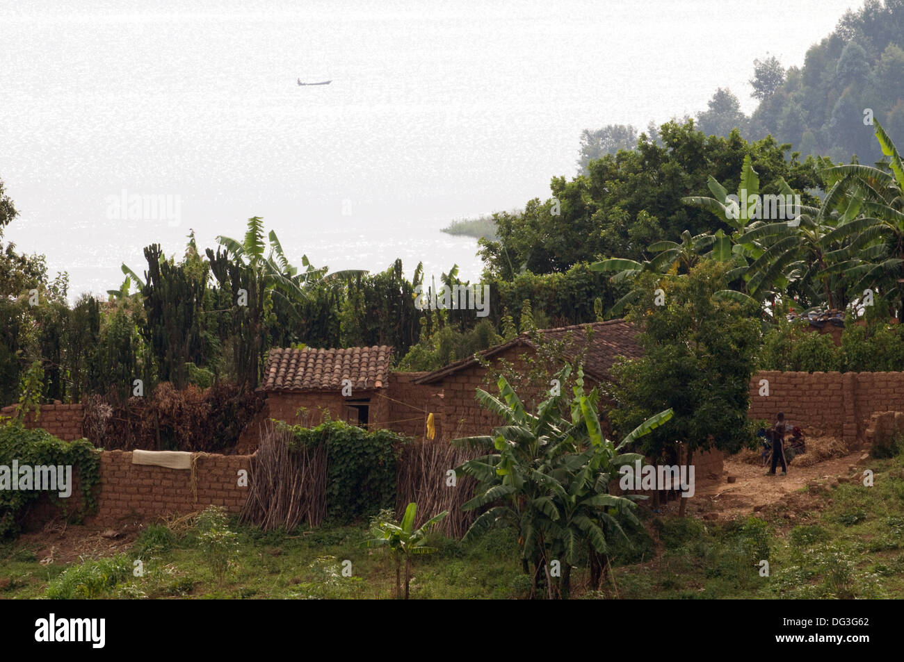 Cascina capanne e contenitori sulle rive del lago Kivu impostato tra banana e alberi da bosco di Gisenyi Rwanda Foto Stock