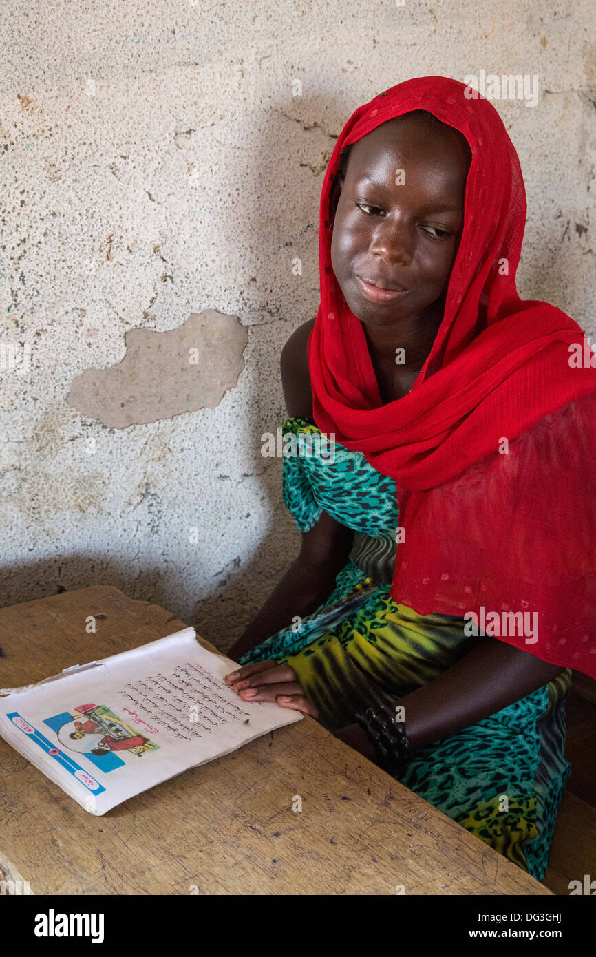 Il Senegal, Touba. Giovane ragazza a Al-Azhar madrasa, una scuola di studi islamici. Il suo libro mostra che ella è imparare l'Arabo. Foto Stock