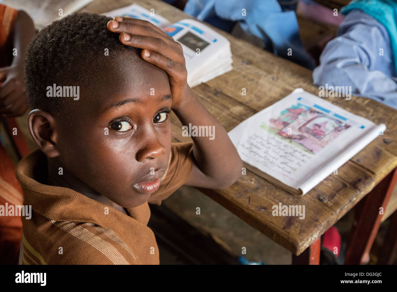 Il Senegal, Touba. Ragazzo giovane a Al-Azhar madrasa, una scuola di studi islamici. Il suo libro mostra che egli è imparare l'Arabo. Foto Stock